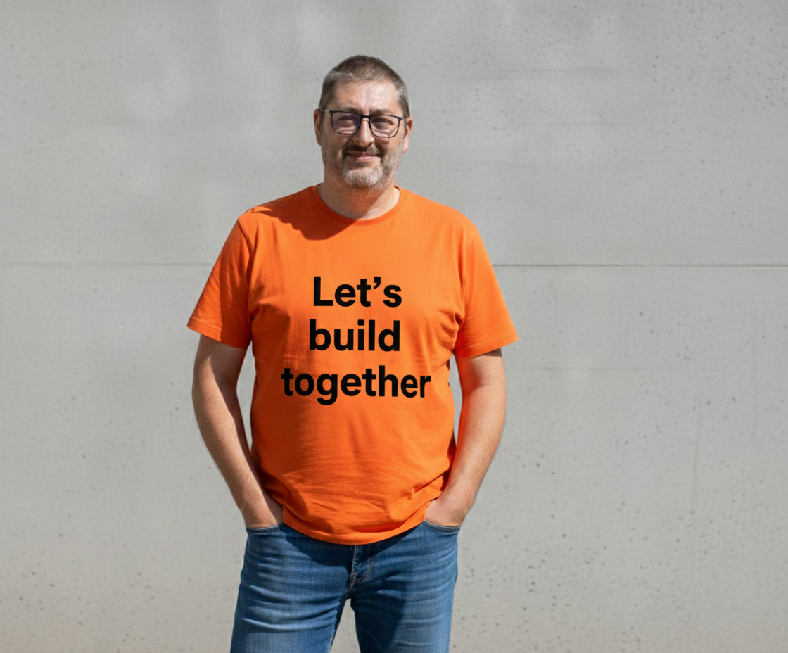 Frederik Vantroys wearing an orange shirt with text Let's build together